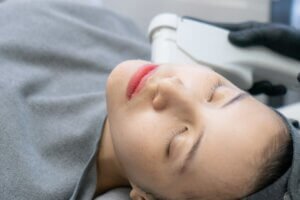 Asian female having HIFU treatment on her face and neck