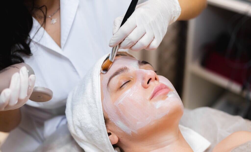 Beautician applying facial to woman